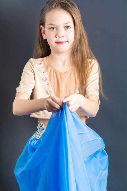 Beautiful girl in a blue dress performs oriental dances - Zdjęcie, obraz