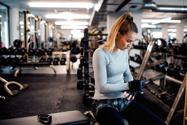 Young girl or woman with dumbbells, doing workout in a gym. - Fotó, kép
