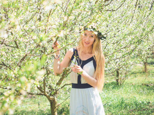 Young beautiful smiling woman in spring blossom trees. - Foto, immagini