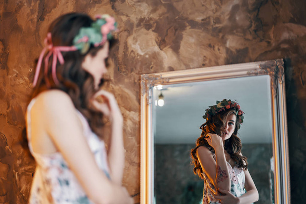 Hermosa joven mirando su reflejo en el espejo. concepto de vestir chica
              - Foto, imagen