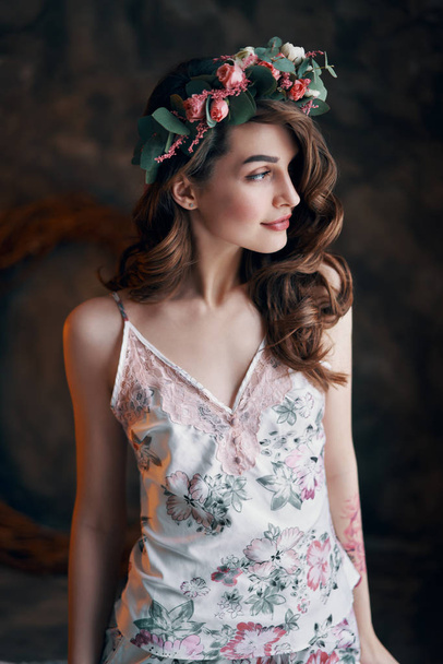 Beauty portrait of young woman with wreath of flowers in her hair. Fashion concept                                - Fotó, kép