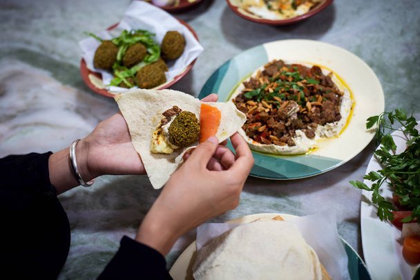 Mujer comiendo comida árabe en un restaurante
 - Foto, Imagen