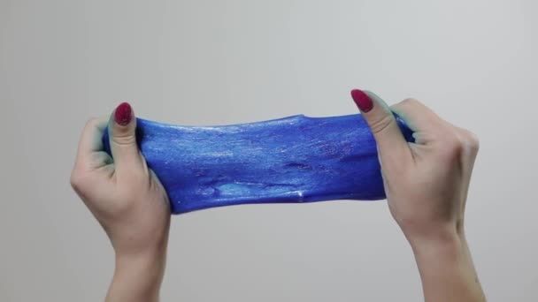 Kadın elleri garip bir şekilde tatmin edici mavi yapışkan maddeyle oynuyor. Stres önleyici - Video, Çekim