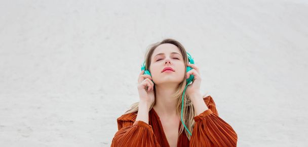 Jovem mulher na blusa cor Borgonha com fones de ouvido
 - Foto, Imagem