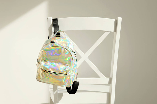 stylischer Rucksack aus irisierendem Material auf Stuhllehne - Foto, Bild