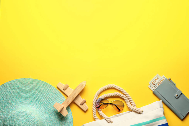 Іграшковий літак з гаманцем, капелюхом, сумкою та сонцезахисними окулярами на кольоровому фоні. Концепція подорожей
 - Фото, зображення