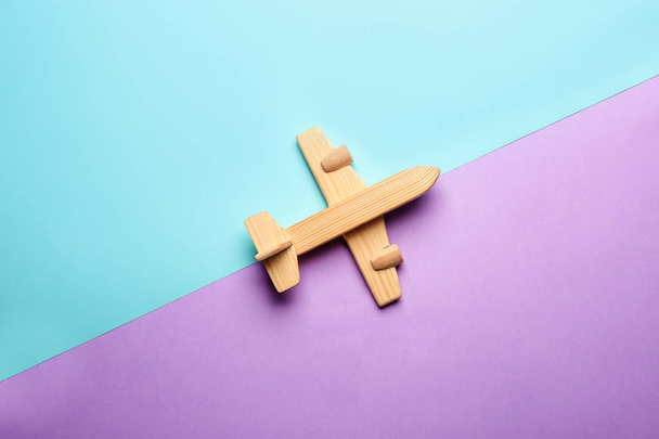 色の背景におもちゃの飛行機。旅行コンセプト - 写真・画像