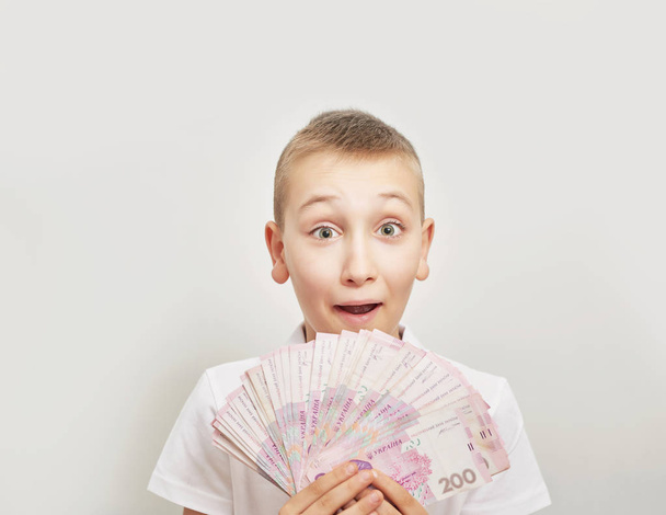 chlapec s penězi hřvnie na bílém pozadí - Fotografie, Obrázek