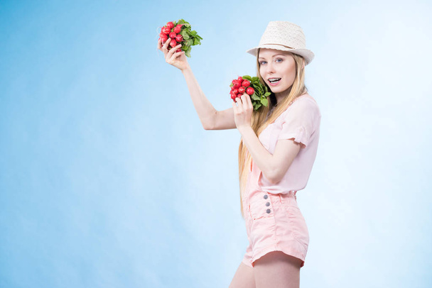 Young woman holding radish - Fotó, kép