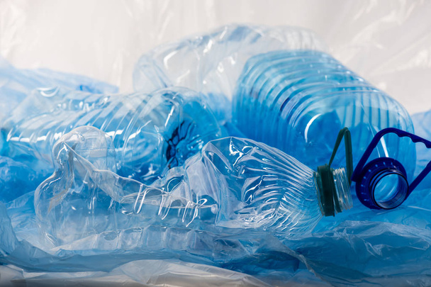 Pile of blue clear plastic bottles and bags being thrown together - Zdjęcie, obraz