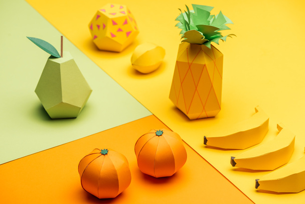 緑、黄色、オレンジの紙に様々な手作りのカラフルな折り紙の果物 - 写真・画像