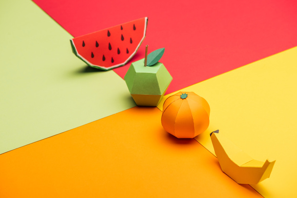 origami karpuz, elma, mandalina ve muz renkli kağıt üzerinde - Fotoğraf, Görsel