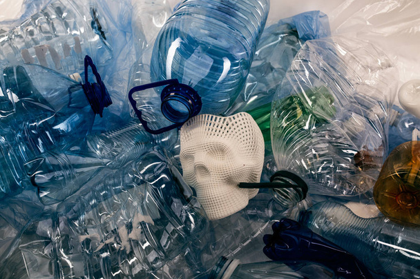 Bunch of transparent plastic water bottles surrounding face skull - Foto, afbeelding