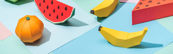 panoramic shot of handmade cardboard fruits on multicolored paper - Фото, изображение