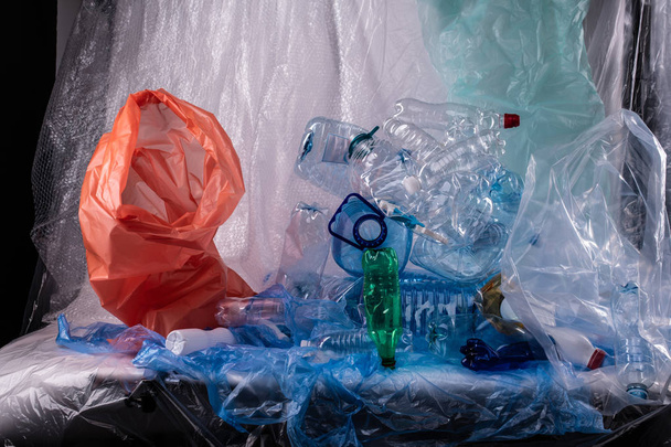 Instalação desagradável com garrafas de água usadas e sacos e ninhadas
 - Foto, Imagem