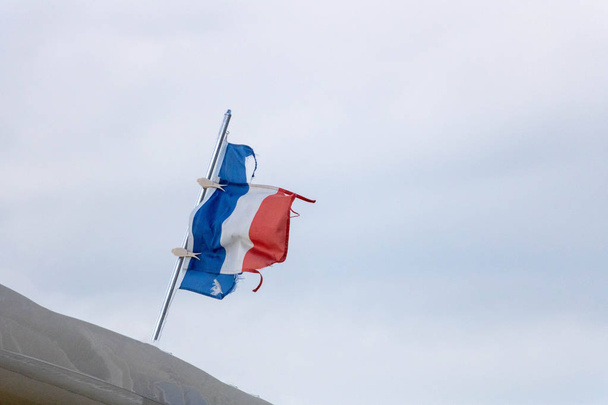 Французский флаг, порванный и отремонтированный прищепками на роскошной лодке
 - Фото, изображение