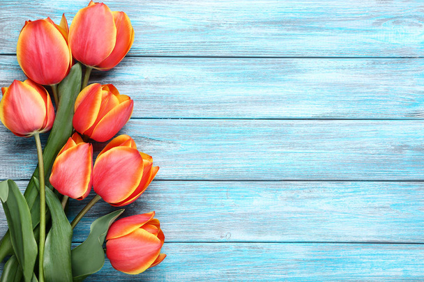 Bouquet of tulips on blue wooden table - Fotoğraf, Görsel