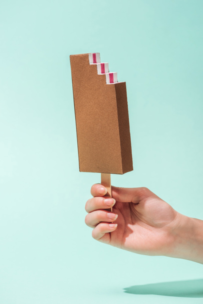vista recortada de la joven mujer sosteniendo helado de papel en turquesa
 - Foto, Imagen