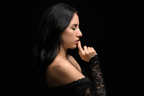 Portrait of beautiful woman on dark background - Photo, Image