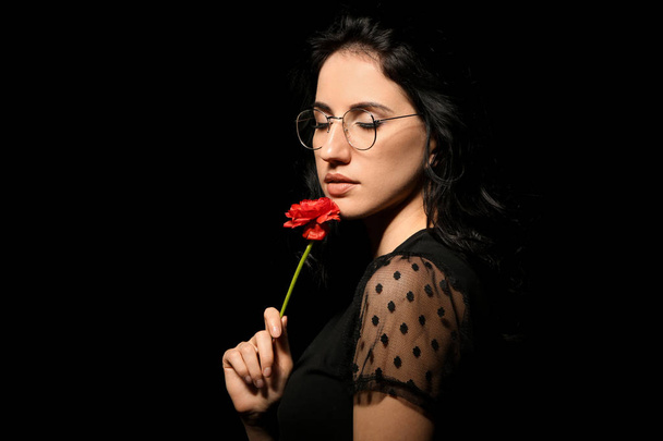 Portrait of beautiful woman with flower on dark background - Photo, Image