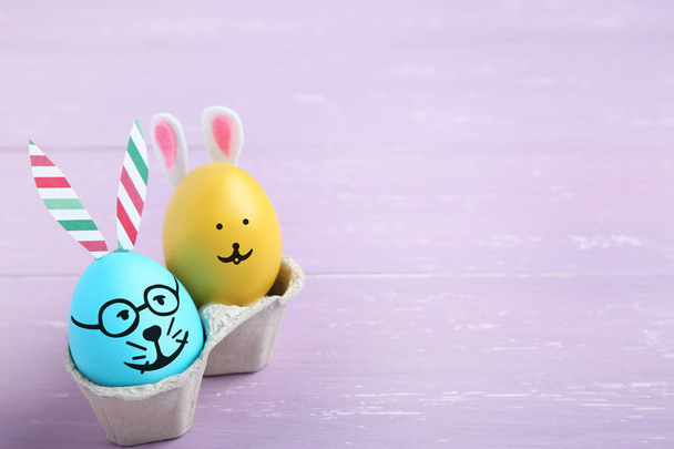 Cute easter eggs on purple woden table - Photo, image