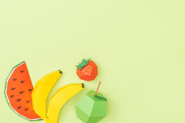 top view of colorful origami bananas, apple, strawberry and watermelon isolated on green with copy space - Φωτογραφία, εικόνα