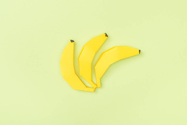 top view of yellow paper bananas isolated on green - Photo, Image