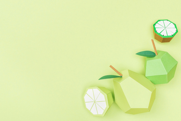 Draufsicht auf handgeschöpftes Papier Limette, Zitrone, Birne und Apfel isoliert auf Grün mit Kopierraum - Foto, Bild