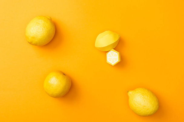 vista superior de limones de papel hechos a mano y limones maduros enteros aislados en naranja
 - Foto, Imagen