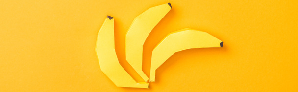 panoramic shot of yellow paper bananas isolated on orange - Photo, Image