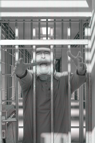 psychiatrische Krankheit, Psychopath, Anstalt, psychiatrisches Krankenhaus, verrückter Mann, der durch die Gitter schreit - Foto, Bild