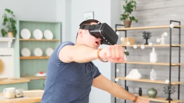 Podekscytowany młody człowiek z wirtualnej rzeczywistości słuchawki taniec i zabawy 360 gier wideo w domu - Materiał filmowy, wideo