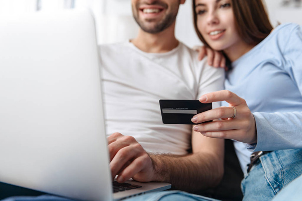 Image of optimistic couple using laptop and credit card together - Fotoğraf, Görsel