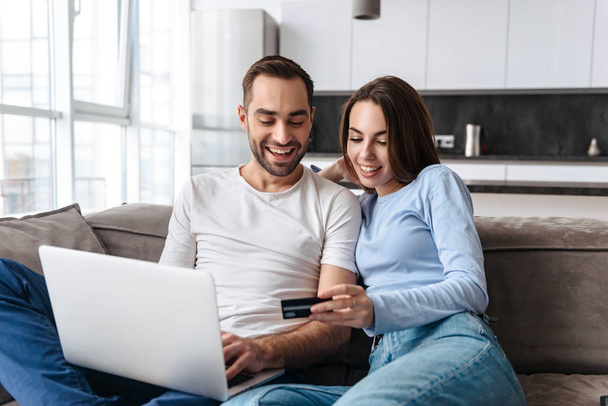 Image of lovely couple using laptop and credit card together for - Foto, imagen