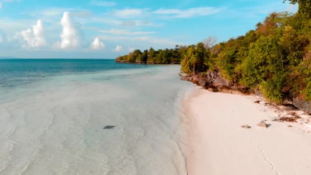 空中スローモーション:熱帯の島のターコイズブルーの水白い砂浜、トミア島、ワカトビ海洋国立公園、インドネシア、ティールオレンジグレーディングを歩く女性 - 映像、動画