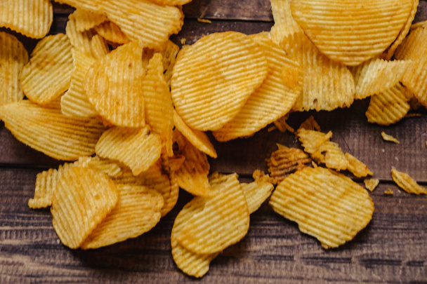 crispy potato chips on wooden background. chips started - 写真・画像