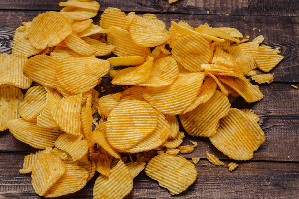 ropogós burgonya chips a fa háttér. elindított zsetonjai - Fotó, kép