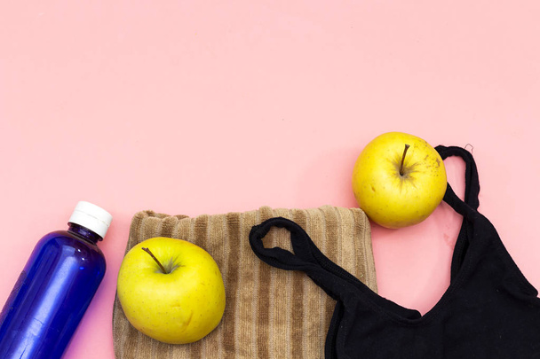 Sportausrüstung flach gelegt, gelbe Äpfel und Wasserflasche, Turnschuhe, schwarzer BH. Konzept gesunder Lebensstil, Sport und Ernährung. - Foto, Bild
