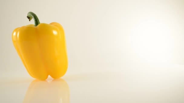 rotující žlutá paprika na akryl proti bílé - dolly vlevo - Záběry, video
