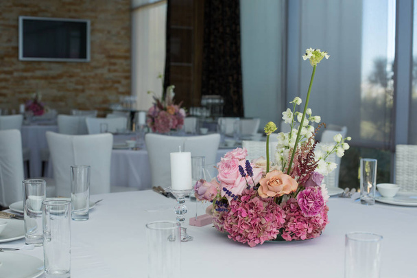 Tapahtuma valkoinen ravintola pöytä tarjoillaan ja koristeltu herkkä tuoreita kukkia
 - Valokuva, kuva