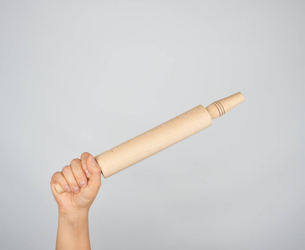 hand holding a wooden rolling pin  - Foto, Imagem