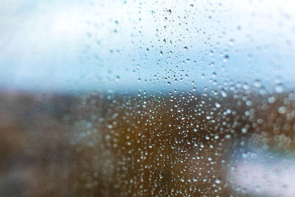 raindrops on the glass against the backdrop of the autumn city - 写真・画像