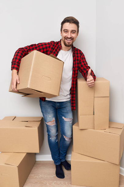 Man gesturing thumb up while moving to new place  - Foto, imagen
