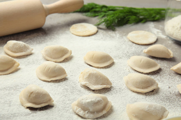 Raw dumplings on grey table, closeup. Process of cooking - Foto, Imagen