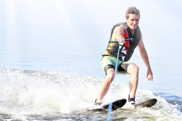 zbliżenie człowiek jazda nart wodnych na jeziorze w lecie w słoneczny dzień. Aktywnych sportów wodnych. Miejsca na tekst - Zdjęcie, obraz