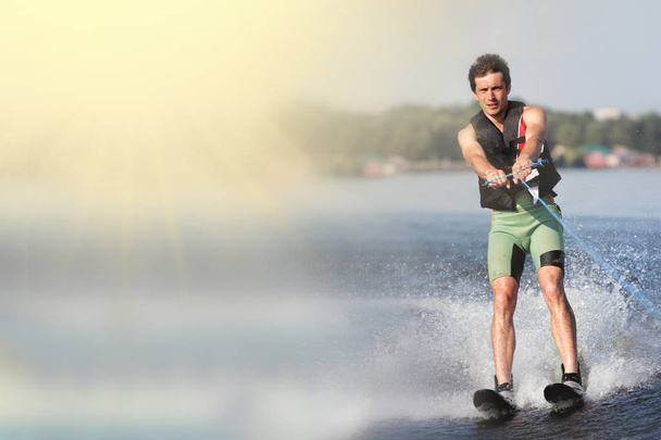 closeup homem montando esquis aquáticos no lago no verão no dia ensolarado. Desporto ativo aquático. Espaço para texto
 - Foto, Imagem