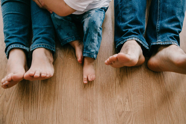 familie voeten op hun thuis vloer met hun baby - Foto, afbeelding