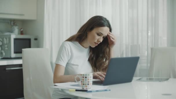 Aggódó nő dolgozik laptop számítógép otthon. Töprengő nő keres laptop - Felvétel, videó