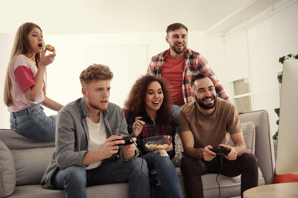 Emotional friends playing video games at home - Photo, image