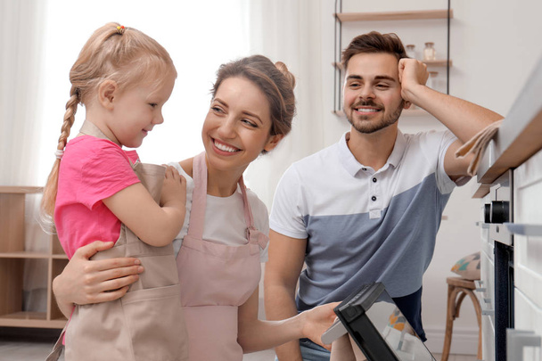 Happy family baking food in oven at home - Photo, Image